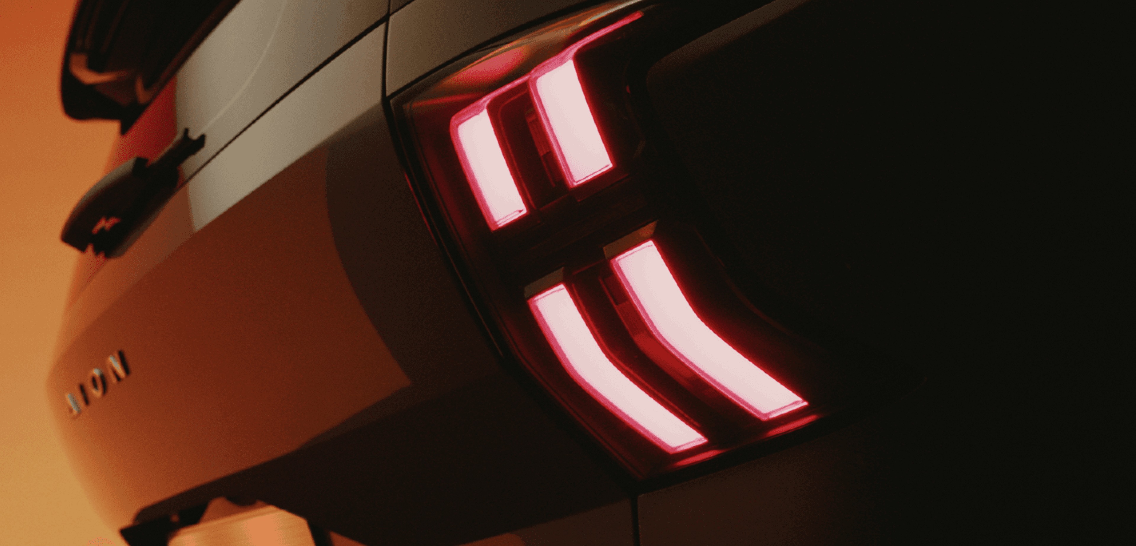 AION V driving through a town street at dusk. 317 miles epic range¹, 24 mins rapid charge², 500 litre boot volume, and 8-year warranty*.